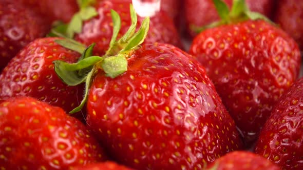 Drops of water fall on strawberries.