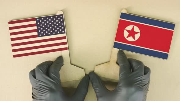 Flags of the USA and North Korea Made of Cardboard on the Desk