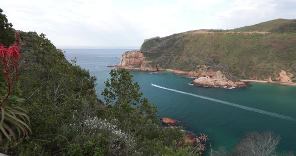 A boat cruise over the bar in the Knysna Heads on its way in summer out to sea on the Indian ocean f