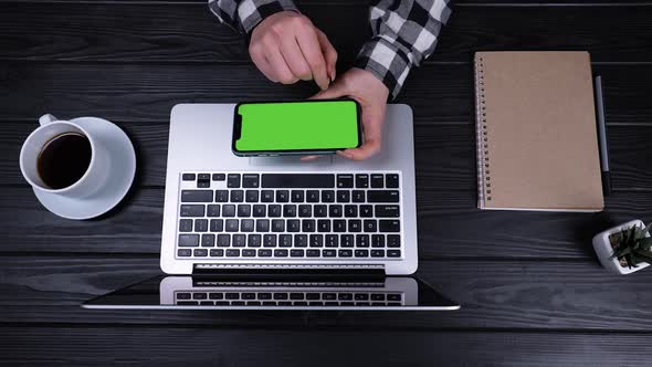 An Overhead View of the Girl's Hands Holding a Smartphone with a Green Screen and a Chrome Key