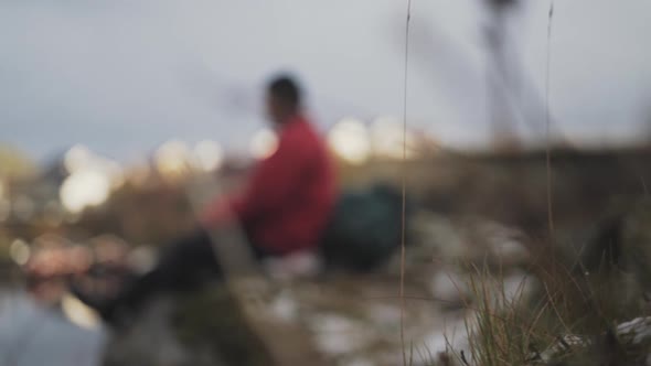 Resting Hiker Sitting On Rock By Reine