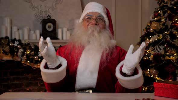 Laughing Santa Claus Looks Camera Sitting on Chair at Desk
