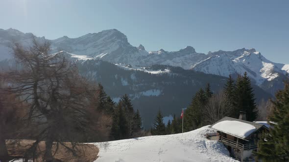 Aerial of beautiful valley, drone pulling back and revealing rustic cabins in beautiful snow covered