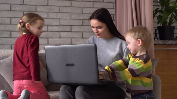 A mother and her children are using a laptop. Family lifestyle, Remote work, distance education