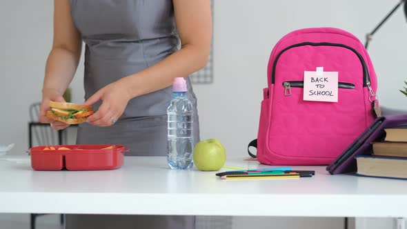 Woman Puts School Lunch in Backpack of Daughter