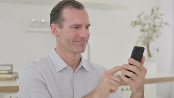 Focused Middle Aged Man Using Smartphone