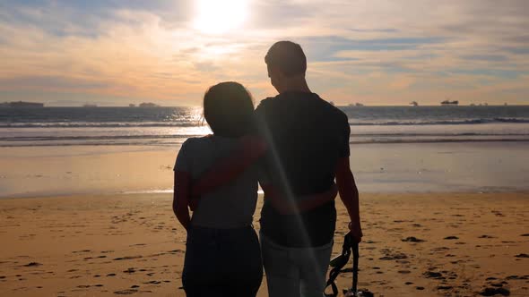 Couple walking their dog on the beach