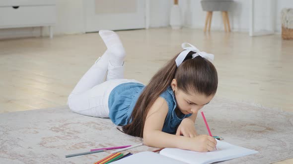 Spanish Spaniard Caucasian Little Small School Girl Daughter Child Pupil Kid Lying on Floor Draws