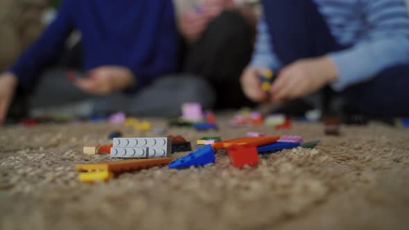 Two boys build a building out of plastic blocks. Сhild playing with a toy constructor