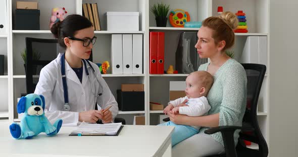 Mom with Child Discussing with Young Doctor