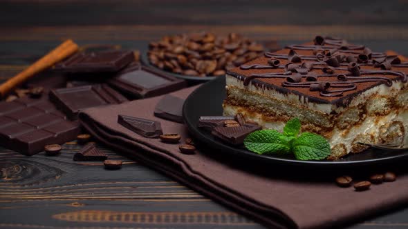 Portion of Traditional Italian Tiramisu Dessert and Pieces of Chocolate Bar