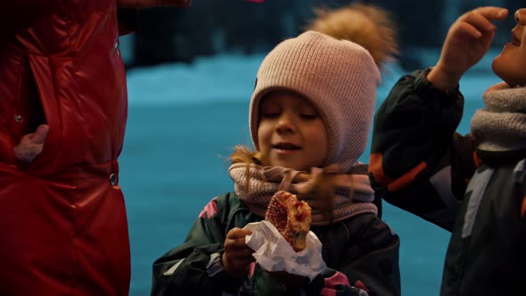 Children Drinking Hot Drinks and Eating Donuts Outdoors