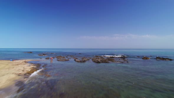 Drone flying at the beach with a clear blue sky