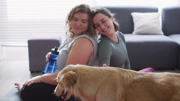 Caucasian lesbian couple keeping fit and resting with dog