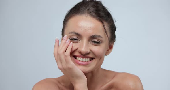 Cheerful Young Woman with Nude Shoulder Smiling After Skin Treatment