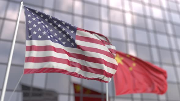 Waving Flags of the USA and China in Front of a Skyscraper