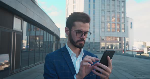 Handsome Bearded Startup Businessman in Glasses Using Mobile Phone