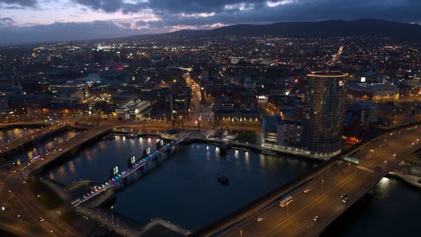 Aerial flyover of Belfast City Centre and Lagan River at night