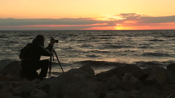 Photographer Taking Photos of Seascape at Sunset