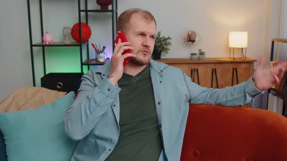 Adult Caucasian Man Enjoying Talking on Mobile Phone Conversation with Friends at Home on Couch
