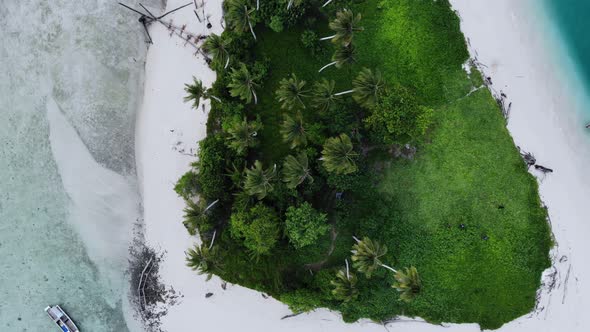 Cinematic overhead aerial view of a beautiful small island beach in the middle of the ocean