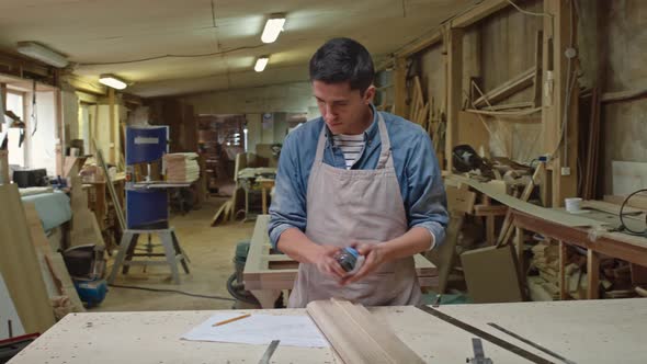 Woodworker Checking Size of Board alt