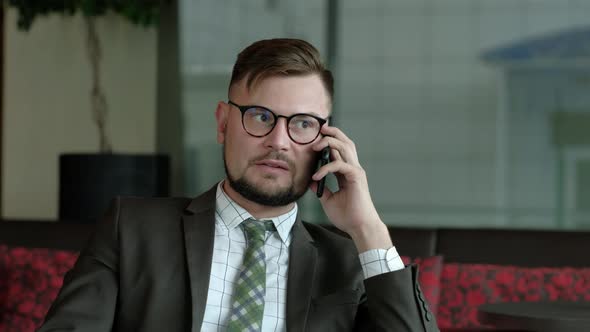 Businessman in office talking on phone.