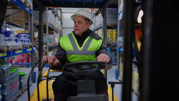 Warehouse Loader Driving Forklift Indoors Looking Around