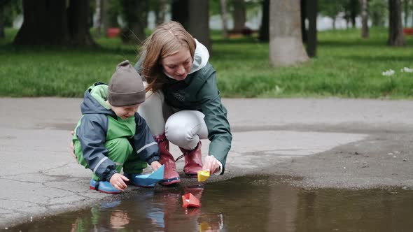 Funny Kid in Rain Boots Playing in a Rain Park