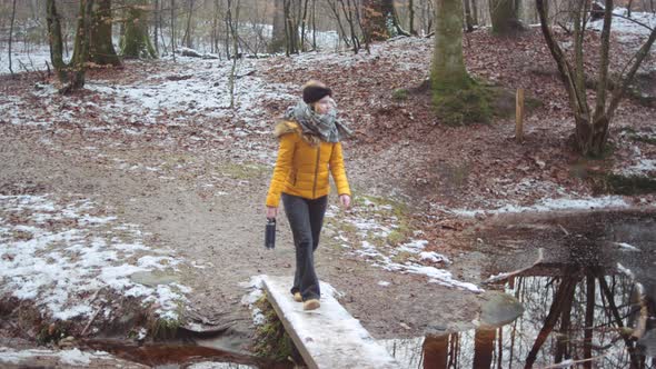 Girl In Yellow Crossing Plank Over Lake