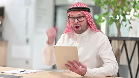 Successful Young Arab Businessman Celebrating on Tablet in Office