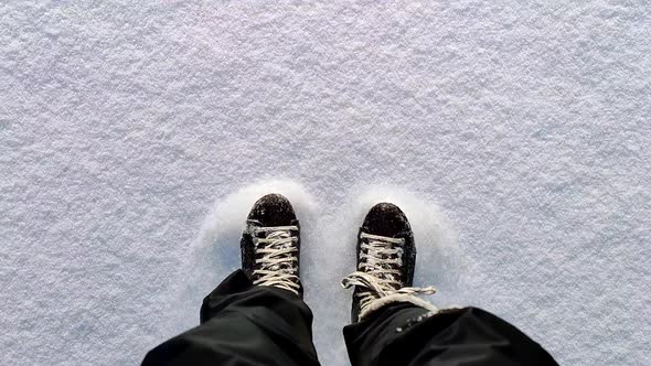 Slow motion shot Pov person with boots ice skating on snow - Top down view