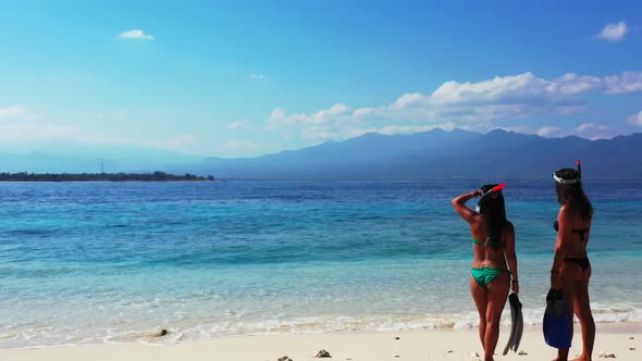 Women best friends on luxury resort beach trip by blue water with white sandy background of Gili Men