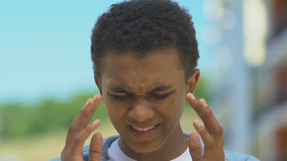 Boy Suffering Migraine Rubbing Head