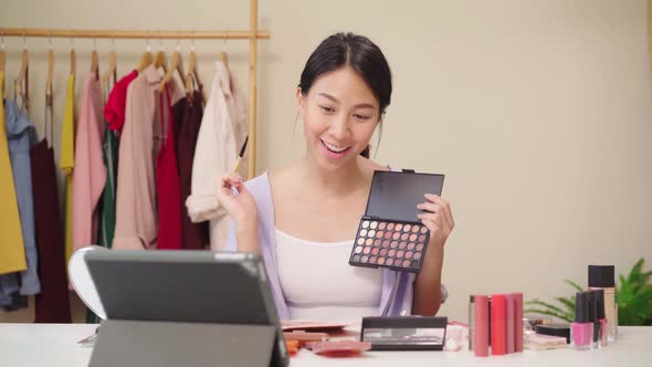 Beauty blogger present beauty cosmetics sitting in front tablet for record video use social network.