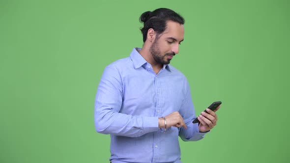 Young Bearded Indian Businessman Using Phone and Looking Surprised