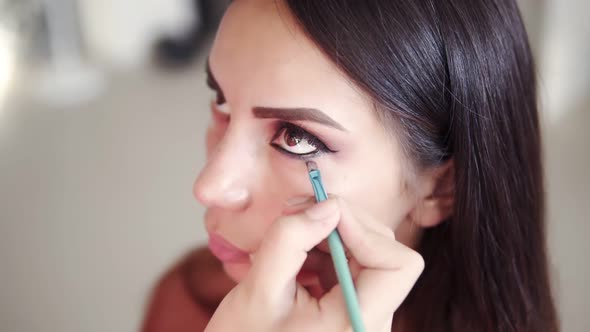 High Angle Footage of Unrecognizable Make Up Artist Applying and Blending Model's Lower Eyelid with
