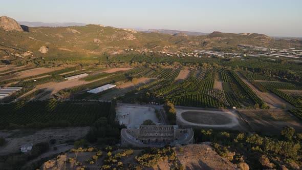 View of the Ancient Theater Across Green Farmland