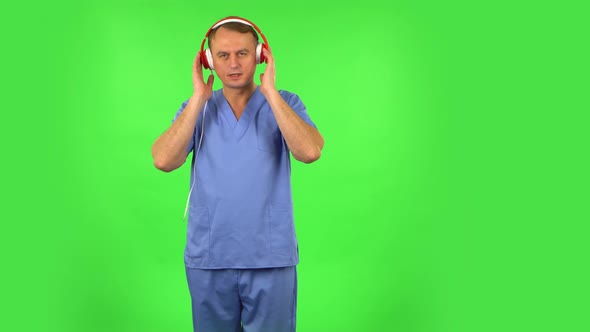 Medical Man Dancing and Singing in Big Red Headphones. Green Screen