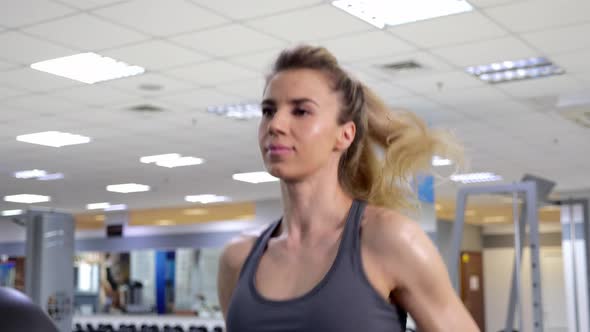 Young sporty Woman On Running Machine In Gym