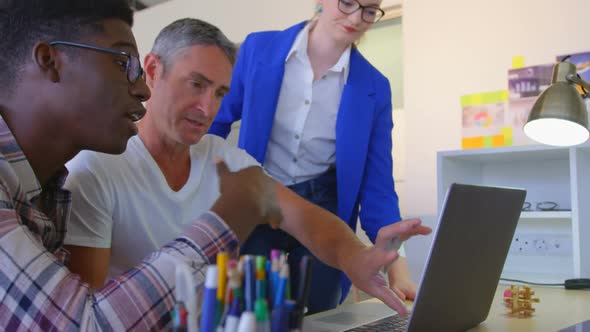 Multi-ethinic business colleagues discussing over laptop in modern office 4k