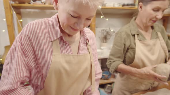 Two Senior Female Crafters Making Clay Bowls in Ceramics Workshop