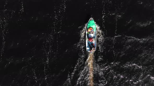 People Sail in Boat on Cold River and Enjoy Cool Autumn Day