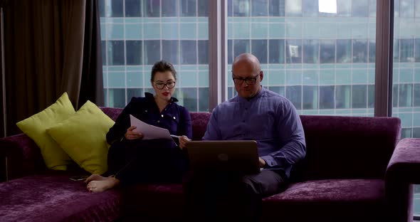 Business Partners Discuss Problems Sitting on Purple Sofa