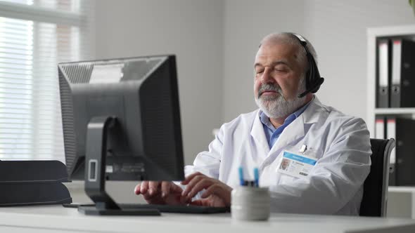 Medicine Technology and Healthcare Concept Senior Male Doctor or Nurse with Headset and Computer