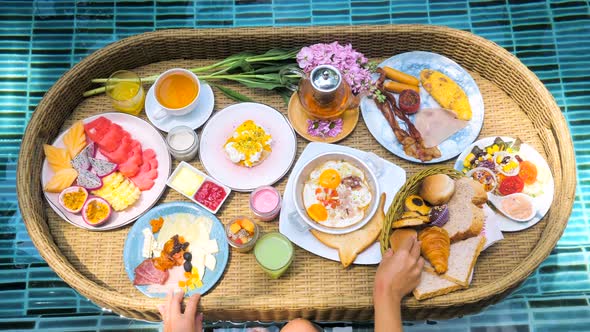 Colorful Meals for Breakfast or Lunch with Woman Hands on Floating Tray in Pool