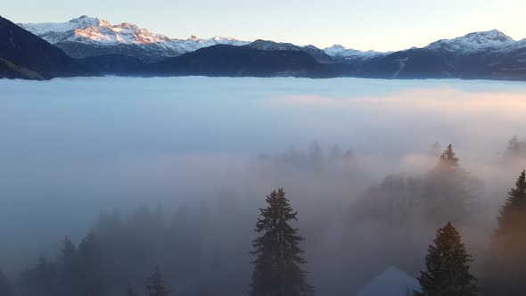 Dense clouds over mountain valley at sunset alt