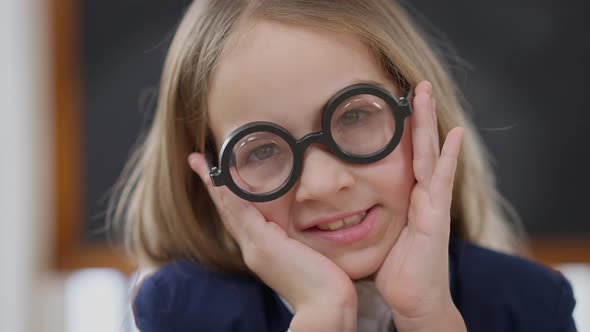 Closeup Face of Nerd Cheerful Schoolgirl in Large Eyeglasses Looking at Camera Smiling