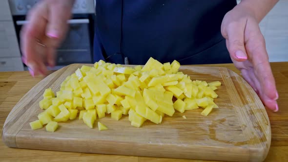 the Chef Cuts the Potatoes Into Cubes and Puts Them in a Baking Dish with Other Ingredients