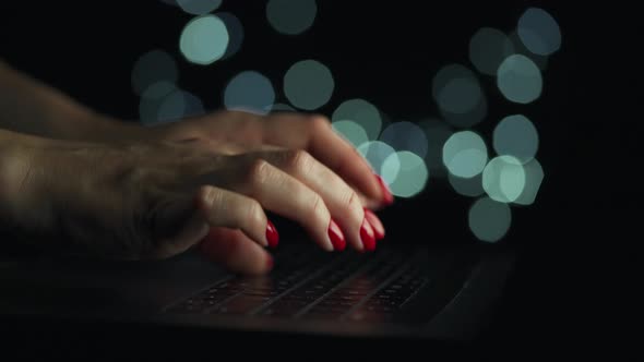 Female Hands is Typing on a Laptop at Night